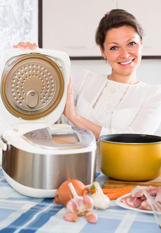 Femme utilisant un multicuiseur