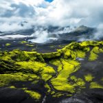 vue-aerienne-dun-paysage-volcanique-en-islande-montrant-des-champs-de-lave-noire-une-mousse-verte-vibrante-et-des-zones-geothermiques-en-ebullition